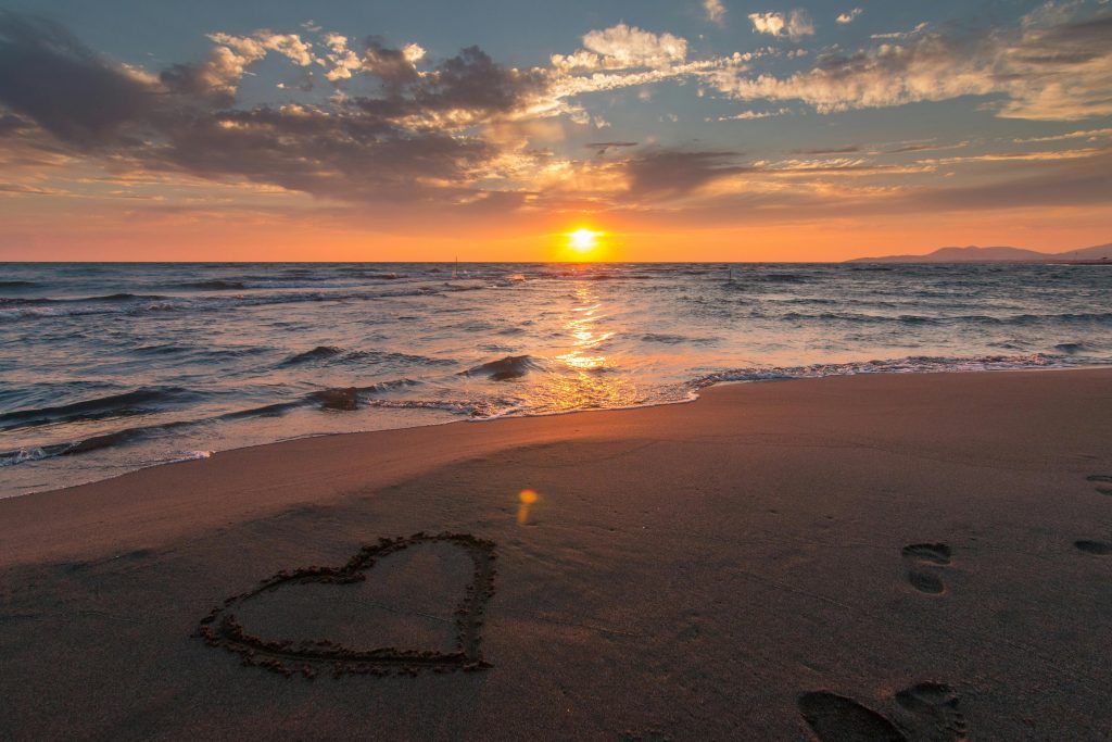pexels-photo-269583-269583 Beautiful sunset over ocean with a heart shape in the sand, perfect for romantic themes.